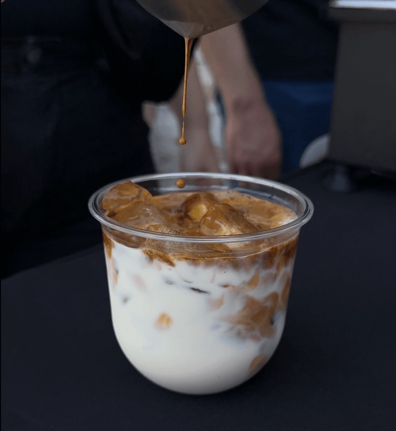 Professional barista preparing espresso drinks at mobile coffee cart event